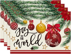 Close-up of linen Christmas placemats with Joy To The World print and pine needles