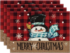 Close-up of four linen Christmas placemats with buffalo plaid and snowman design