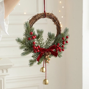 Christmas rattan wreath with red berries, pine needles, bow and gold bells for door decor