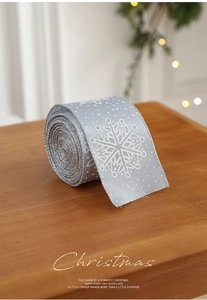 Close-up of light blue Christmas ribbon with white snowflakes and silver glitter edges