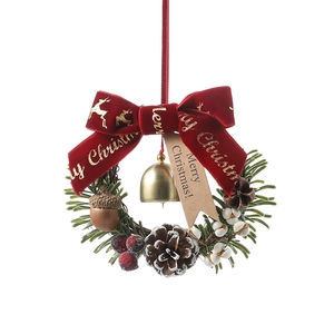 Christmas wreath with red velvet bow, gold bell, pine cones and berries on white backdrop