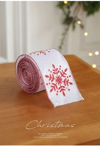 Detail of white Christmas ribbon with red glitter snowflakes and braided edges