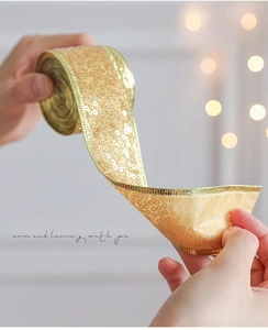 Close-up of golden sequin ribbon with metallic edges for Christmas gift wrapping