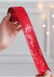 Close-up of red sequin ribbon for Christmas gift wrapping and festive decoration