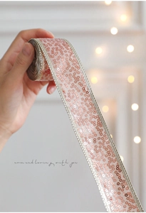 Detailed view of pink sequin ribbon with silver woven edges for gift wrapping decoration