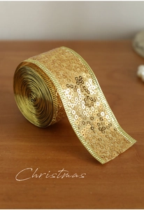 Close-up of golden sequin ribbon with sparkling metallic edges for Christmas decor