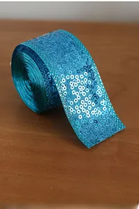 Close-up of bright blue sequin ribbon roll for DIY crafts and gift wrapping decoration
