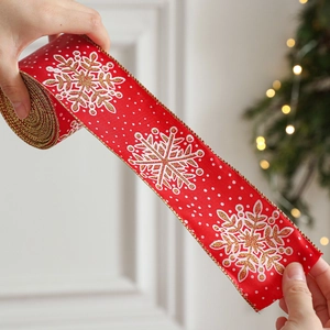 Red Christmas ribbon with gold snowflake patterns and wired edges for gift wrapping