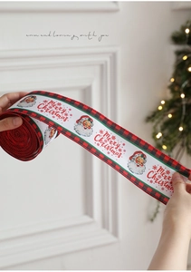 Dettaglio di nastro natalizio con stampa Babbo Natale e bordi scozzesi per pacchi regalo
