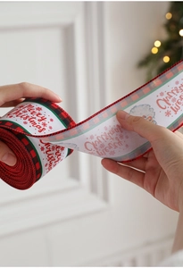 Dettaglio di nastro natalizio con testo Merry Christmas e Babbo Natale per pacco regalo