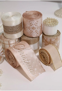 Close-up of champagne and rose gold Christmas ribbons with glitter snowflakes and patterns