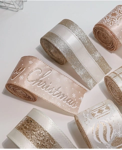 Detail of champagne gold and pink Christmas ribbons with Merry Christmas text and snowflake patterns
