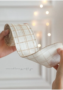 Close-up of cream and gold plaid Christmas ribbon with elegant metallic wire edges