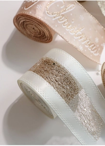Close-up of champagne Christmas ribbon with white glitter snowflake patterns and gold mesh detail