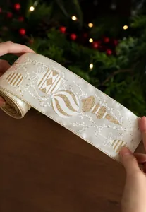 Detail of cream Christmas ribbon with gold glitter ornaments and sparkling edges