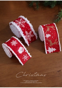 Detailansicht von drei roten Weihnachtsbändern mit Schneeflocken und Rentieren auf Holz