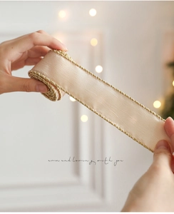 Detail of champagne gold organza ribbon with fine gold thread woven edges for gift wrapping