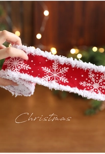 Nahaufnahme von rotem Weihnachtsband mit Schneeflockenmuster und weißem Plüschrand