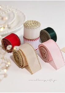 Detail of satin Christmas ribbons with braided edges in red, pink, and green colors