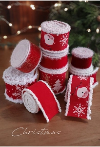 Details von roten Weihnachtsbändern mit weißem Pelzrand und Schneeflockenmuster