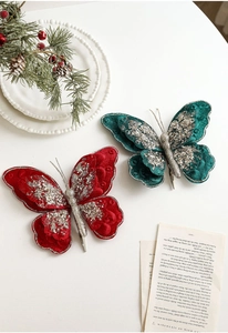Detail von roten und grünen Samt-Schmetterlingsclips mit Glitzer für Weihnachtsdeko