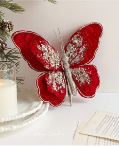 Detail von roter Samt-Weihnachtsschleife mit Silberglitzer und Metallclip am Tannenzweig