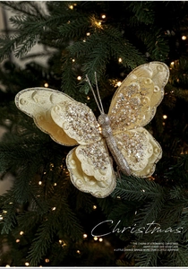 Details von champagnergoldenem Schmetterlingsschmuck mit Pailletten am Weihnachtsbaum
