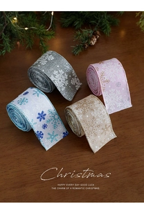 Dettaglio di nastri natalizi in juta con motivi a fiocco di neve e glitter in quattro colori