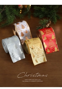 Close-up of four rolls of Christmas satin ribbons with gold foil holiday greetings and trees