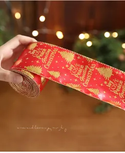 Detail of red Christmas ribbon with gold foil trees and festive greetings on a roll