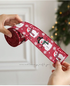 Detail van rood kerstlint met sneeuwpopmotieven en feestelijke zuurstokpatronen