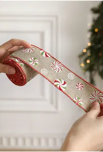 Close-up of burlap Christmas ribbon featuring candy cane swirls and red stitched edges