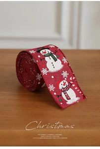 Detail van rood kerstlint van jute met sneeuwpop en sneeuwvlokken op hout