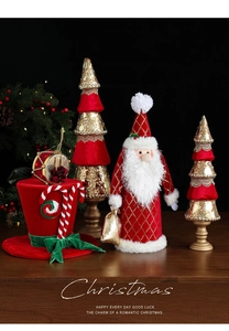 Dettaglio di decori natalizi in velluto rosso con Babbo Natale, alberi di paillettes e cappello