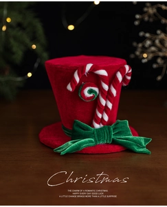 Dettaglio mini cappello natalizio in velluto rosso con fiocco verde e bastoncini di zucchero