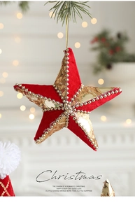 Dettaglio stella di Natale in velluto rosso con paillettes dorate e perle sull'albero