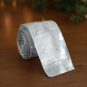 Sparkling silver Christmas ribbon with festive holiday patterns on a rustic wood surface