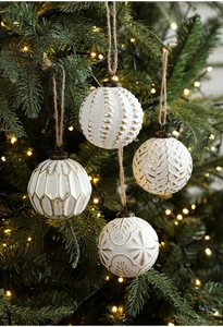 Set of four 8cm cream Christmas balls with gold embossed patterns hanging on a tree