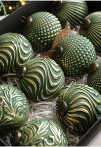 Macro view of vintage dark green and gold embossed Christmas ornaments in a gift box
