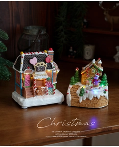 Close-up of lighted resin Christmas candy shop and snowman houses with warm LED glow
