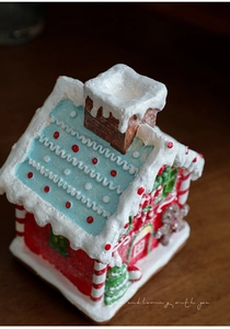Close-up of a resin gingerbread house with snow details and a festive Christmas tree