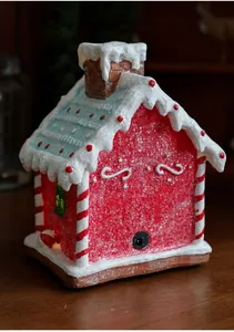 Close-up of lighted resin gingerbread house with snow texture and DC power port detail