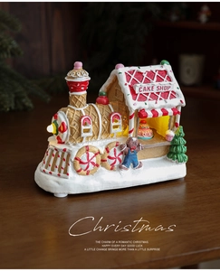 Close-up of glowing LED Christmas train cake shop ornament with gingerbread man and candy details