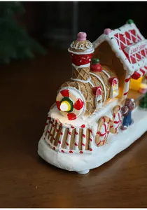 Detail of a glowing Christmas gingerbread cake shop resin house with LED warm lights