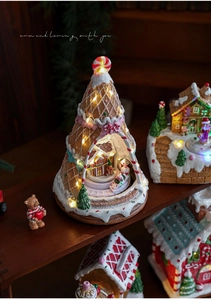 Detail of gingerbread Christmas house with warm LED lighting and miniature spinning scene