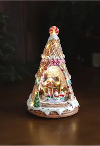 Macro shot of luminous Christmas snow house inside a waffle cone tree with warm LED lights