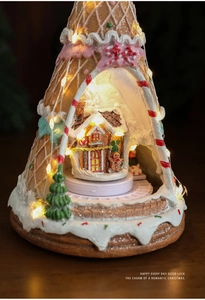 Detail of a resin Christmas gingerbread house with warm LED lights and festive scenery