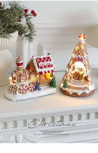 Close-up of lighted resin gingerbread cake shop train and LED Christmas tree ornaments