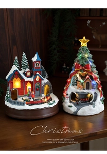 Détail d'une maison de Noël en résine avec train rotatif et lumières LED chaudes