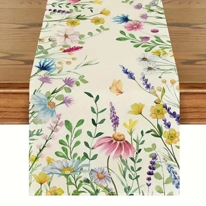 Détail d'un chemin de table à fleurs aquarelles sur un plateau en bois sombre veiné